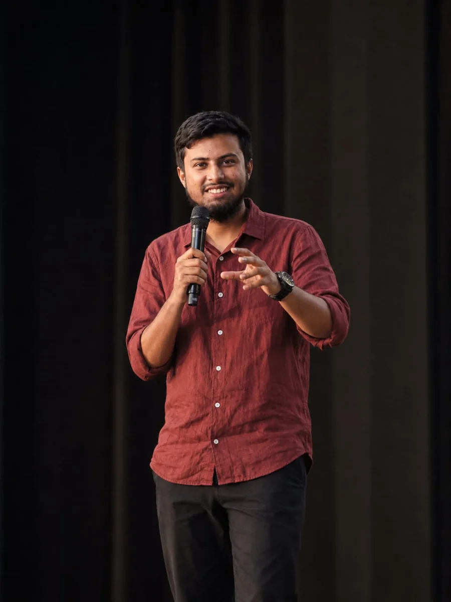 Anayet Ullah speaking on stage with a microphone